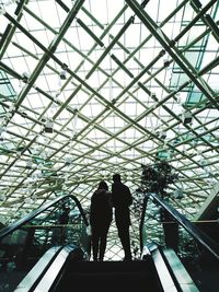 Low angle view of silhouette woman walking on ceiling