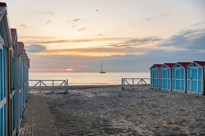 Little blue houses on the beach. a place to store beach utensils. sunset on the mediterranean coast. 