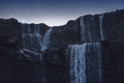 Scenic view of waterfall against sky