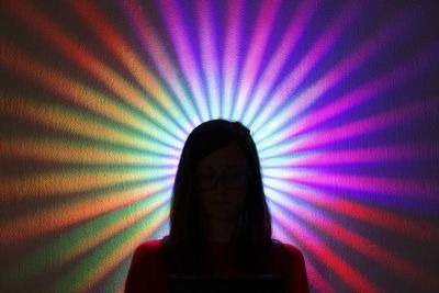 Man photographing illuminated light at night