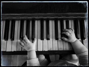 Cropped hand of woman playing piano