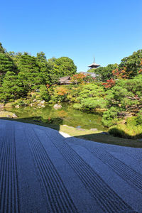 Scenic view of trees and building against clear blue sky