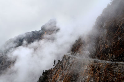 Smoke emitting from volcanic mountain against sky