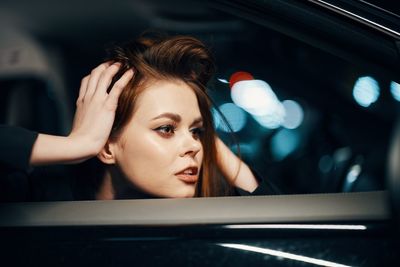 Close-up of young woman looking through window