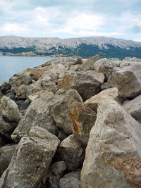 Rocks by sea against sky