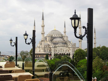 View of buildings in city against cloudy sky