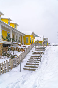 Snow covered houses and buildings against sky