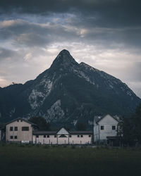 Houses by mountain against sky