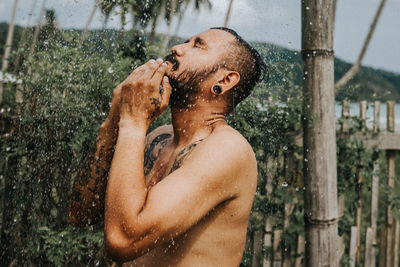 Full length of shirtless man standing in water