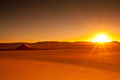 Scenic view of desert against sky during sunset