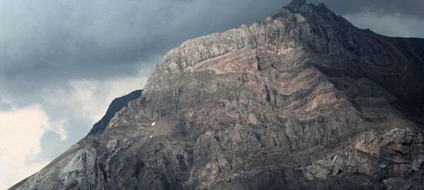 Low angle view of rocky mountain against sky