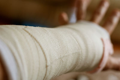 Close-up of human hand on bed