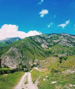 Scenic view of landscape and mountains against blue sky