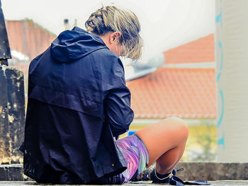 Rear view of woman sitting outdoors