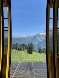 Scenic view of mountains against clear sky seen through window