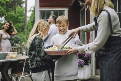 Happy siblings looking at food during dinner party