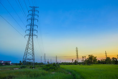 Electricity pylon on field against clear sky