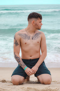 Young man sitting on beach