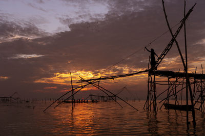 Silhouette sailboats in sea against sky during sunset