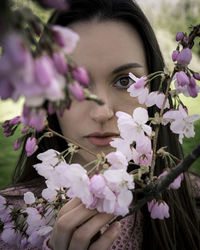 Close-up of woman with pink flower