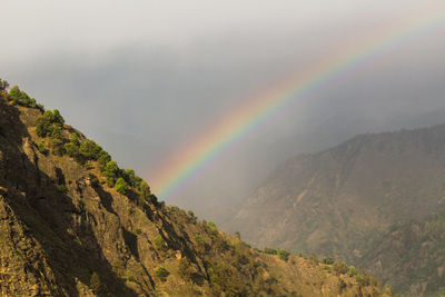 Rainbow over mountain against sky