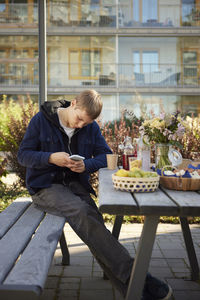 Teenage boy using phone at outdoor party