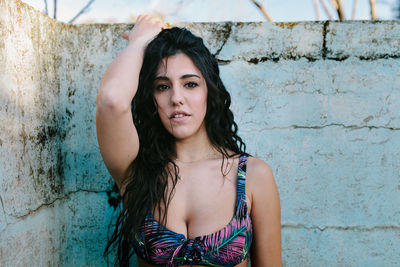 Portrait of beautiful woman standing at abandoned swimming pool