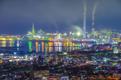 Illuminated cityscape against sky at night