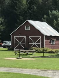 Built structure on field by house against sky