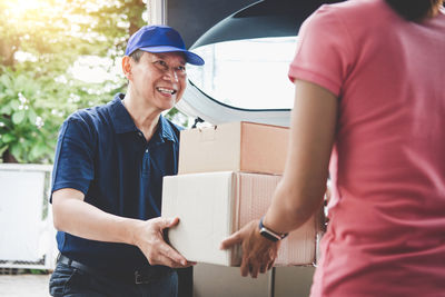 Smiling delivery man giving boxes to woman