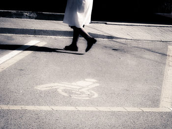 Low section of woman walking on road