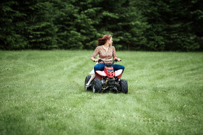 Father and daughter riding horse on grass