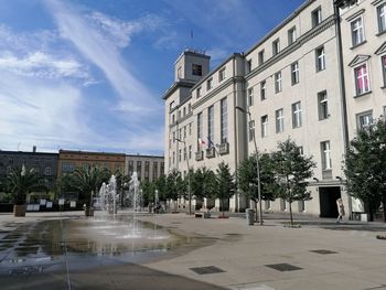 Fountain in city against sky