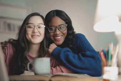 Two women laugh looking at the laptop