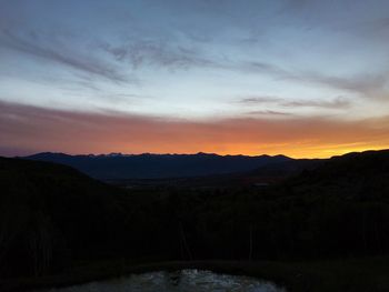 Scenic view of silhouette mountains against sky at sunset