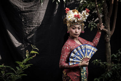 Portrait of woman wearing traditional clothing standing in forest