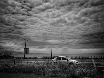 Car on grass against sky