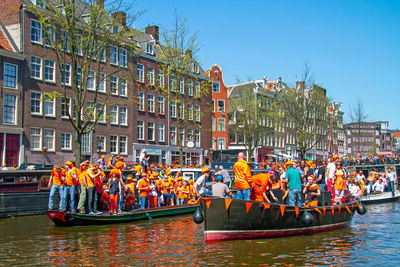 Dutch citizens celebrating kingsday on the canals from amsterdam in the netherlands