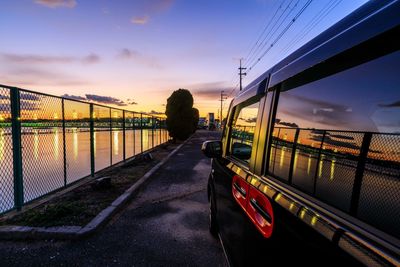 Rear view of train on road against sky during sunset