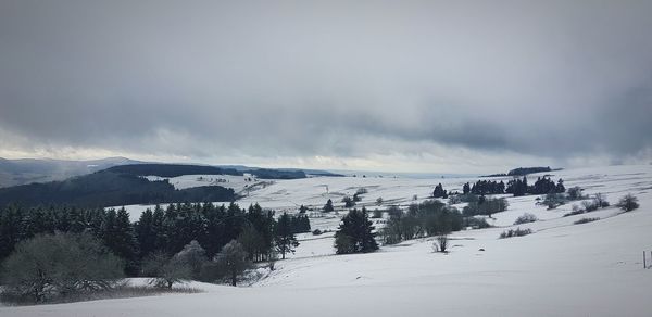 Panoramic view of snow covered landscape against sky