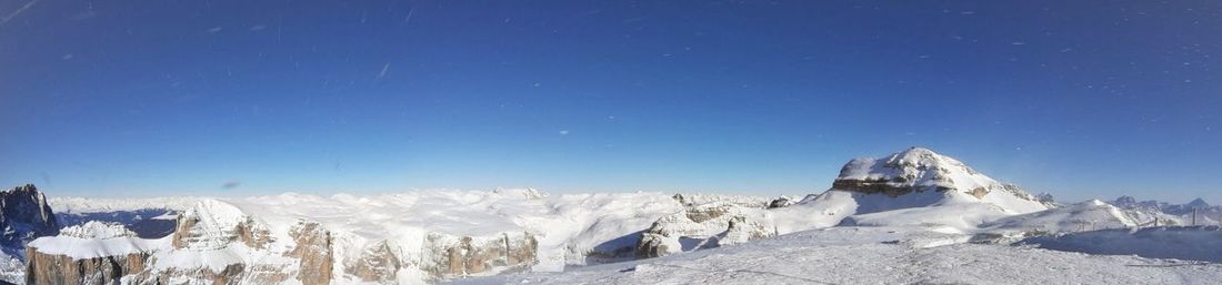 Panoramic view of snowcapped mountains against clear blue sky