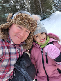Rear view of mother and daughter in snow