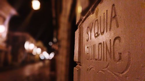 Close-up of illuminated text on wood at night