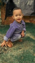 Portrait of boy  sitting on grass