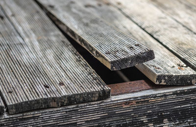 Exterior pine wooden floor bending due to climate change, front focus blurred background