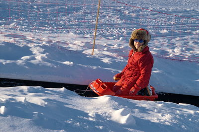 Woman sitting on snow covered mountain