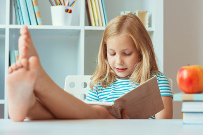 Girl sitting on table at home