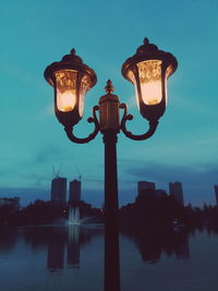 Low angle view of illuminated street light against sky