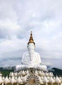 Low angle view of sculpture and building against sky