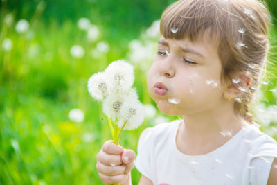 Portrait of girl blowing dandelion